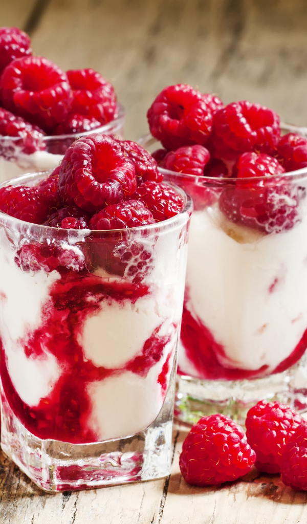 Сладкий десерт с йогуртом и малиной в стакане