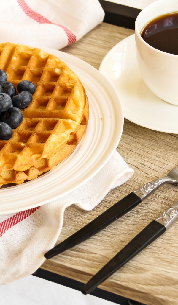 Сладкие вафли с черникой и чашкой кофе на завтрак