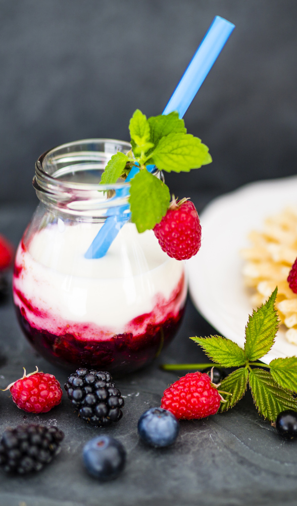 Тонкие хрустящие вафли на столе с ягодами и коктейлем