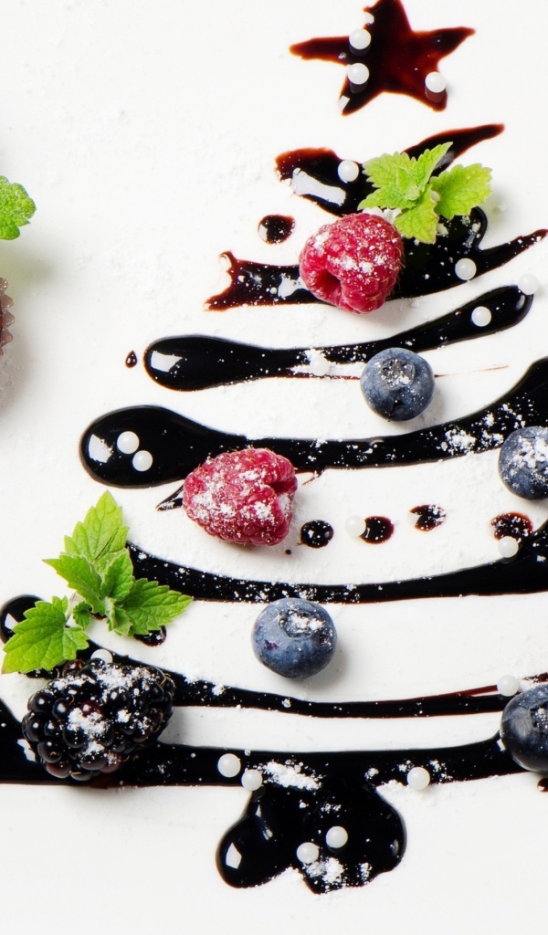 Три кекса и нарисованная шоколадом елка на белой тарелке