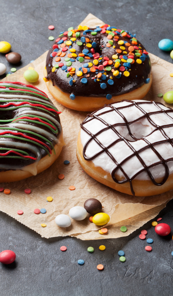 Три аппетитных сладких пончика с конфетами 