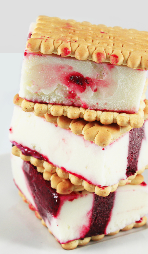 Три кусочка мороженого с печеньем на сером фоне