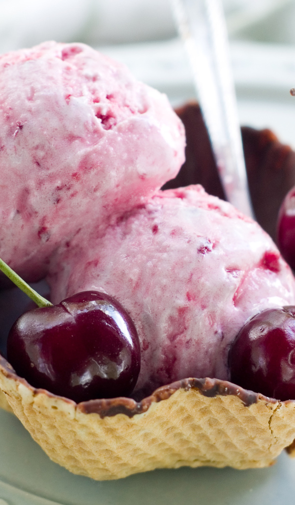 Два шарика вишневого мороженого в вафельной корзинке