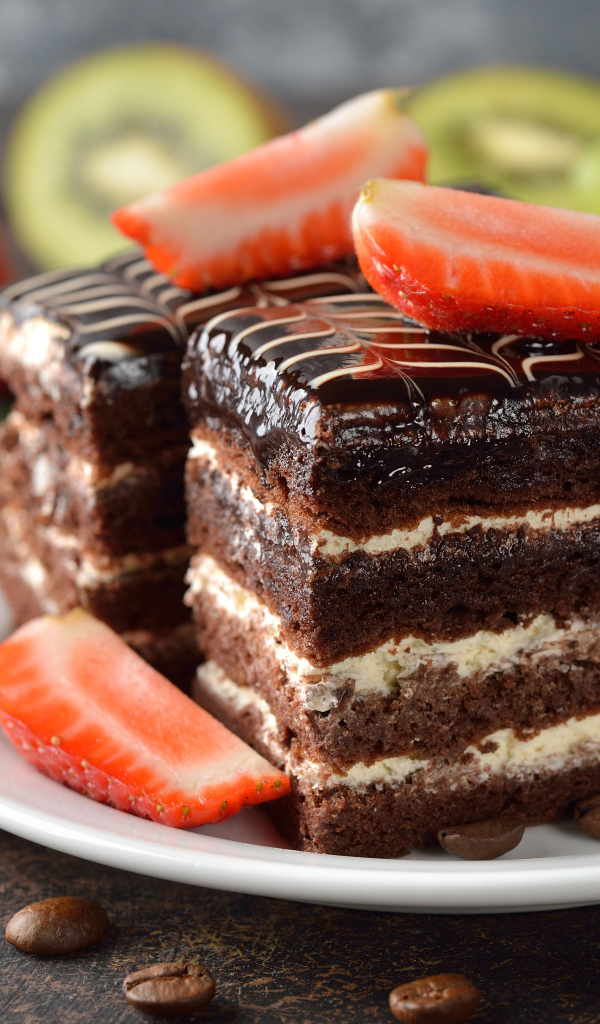 Два кусочка шоколадного пирожного с ягодами клубники