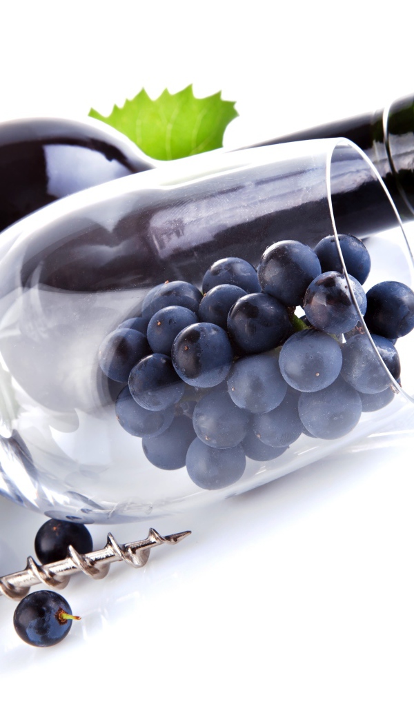 Бутылка вина с бокалом и виноградом на белом фоне