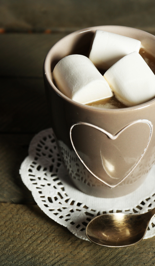 Чашка какао с кусочками маршмеллоу на кружевной салфетке
