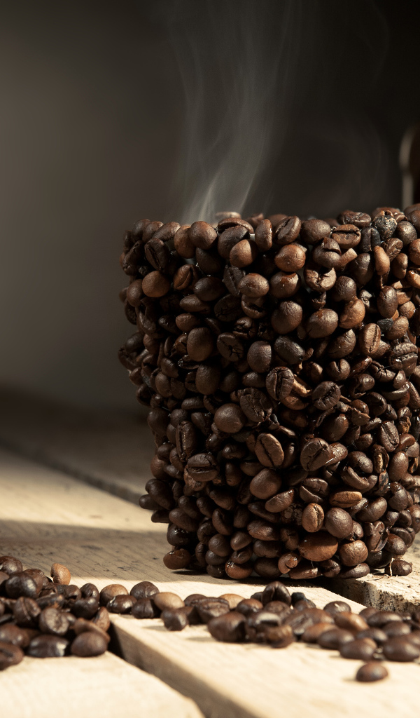 Чашка из кофейных зерен с горячим кофе 