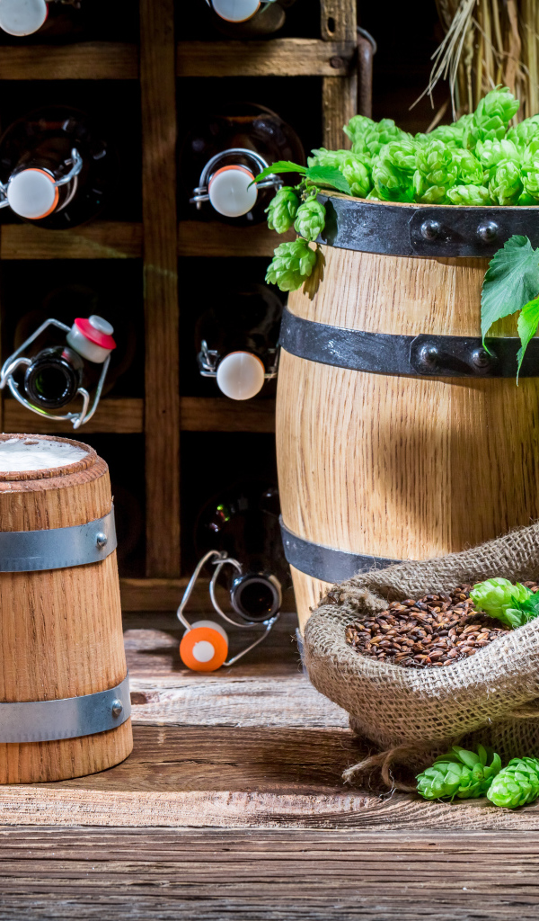 Бокал пива и деревянная бочка с хмелем на столе