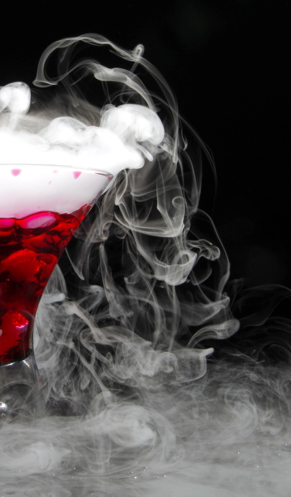 Коктейль с сухим льдом на черном фоне