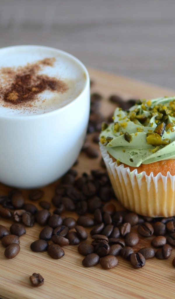 Кофе с аппетитным капкейком стоят на кофейных зернах