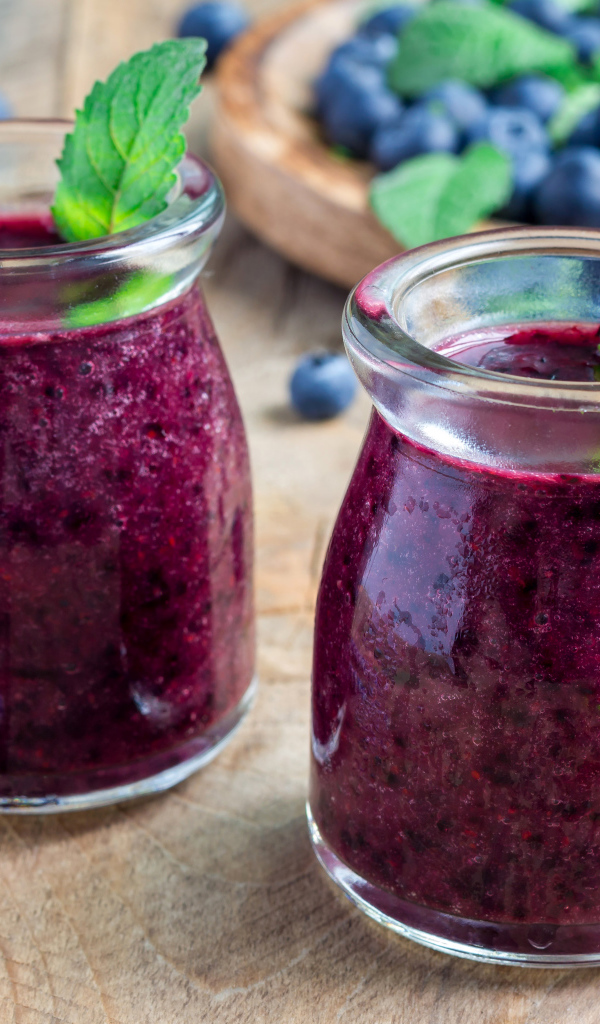 Вкусный черничный смузи с ягодами свежей черники на столе