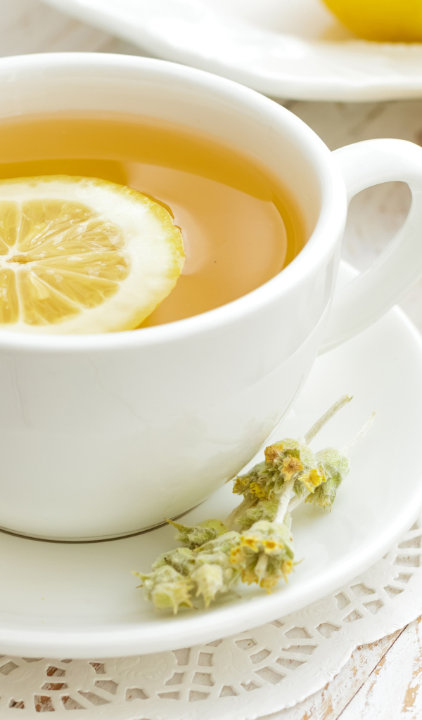 Зеленый чай с лимоном в белой чашке 