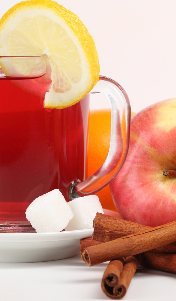 Чай с лимоном, яблоками и корицей на белом фоне