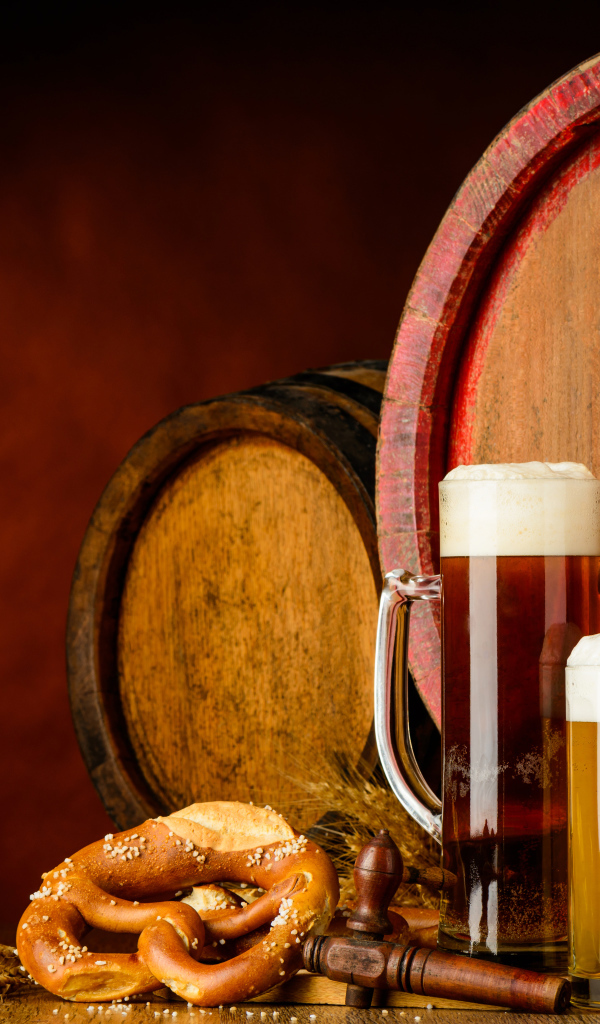 Два бокала пива и выпечка у пивных бочек