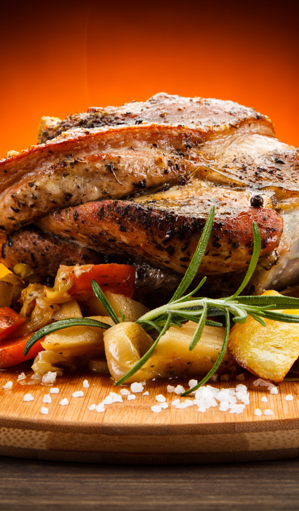 Аппетитный сочный кусок мяса с овощами и солью на разделочной доске