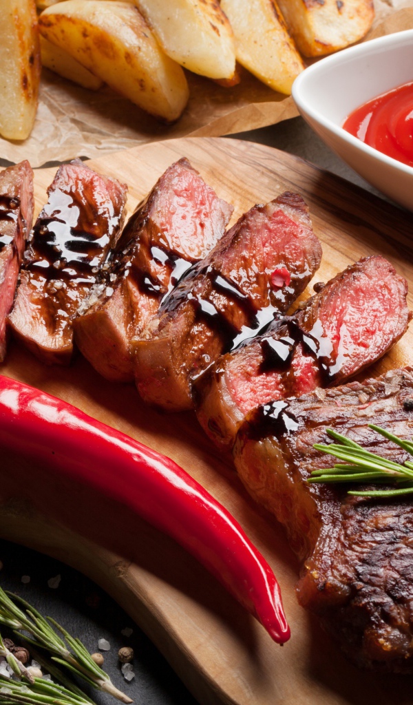 Аппетитный сочный стейк с соусом, красным перцем и специями на столе