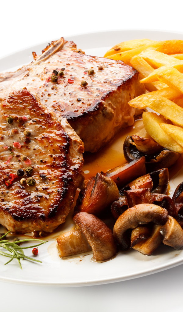 Аппетитный кусок жареного  мяса с картошкой фри и грибами 