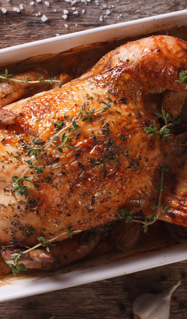 Запеченная аппетитная курица на со специями на столе