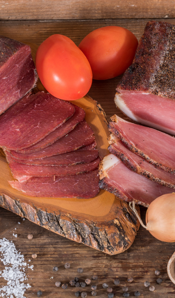 Вкусное вяленое мясо со специями на разделочной доске