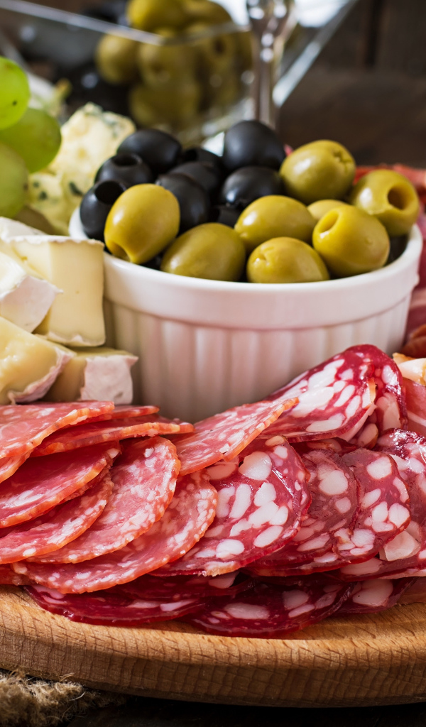 Мясная нарезка с сыром и оливками на разделочной доске