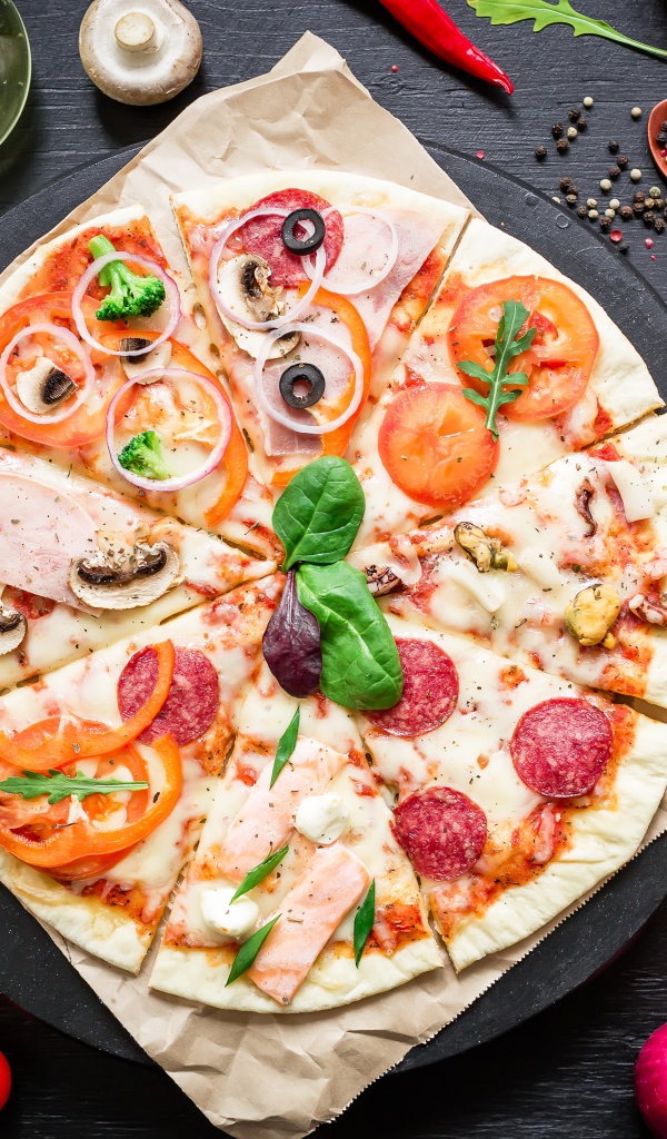 Аппетитная пицца на столе со специями и помидорами