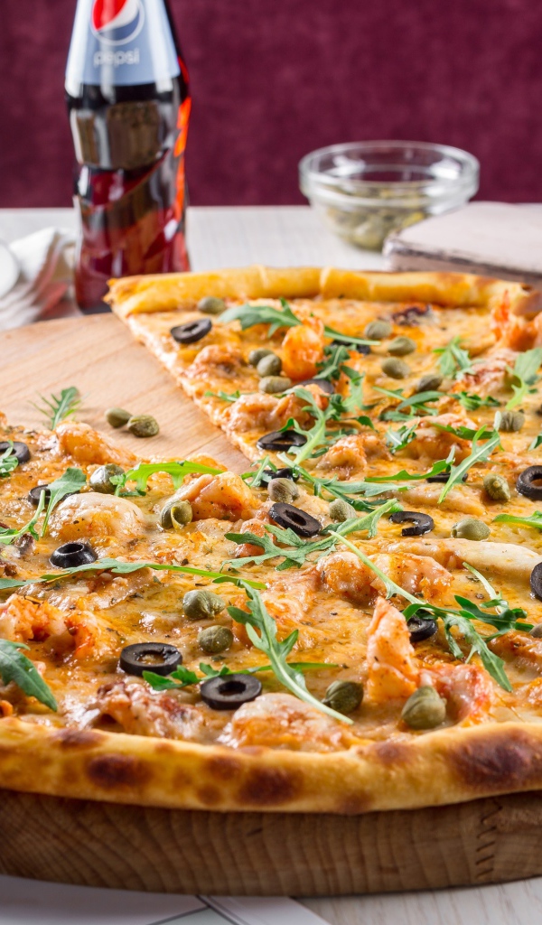 Пицца с оливками на столе с бутылкой пепси