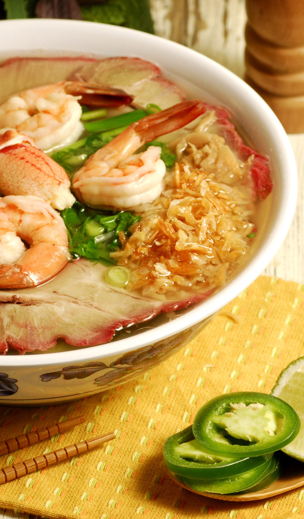 Тарелка супа с креветками и морепродуктами на столе