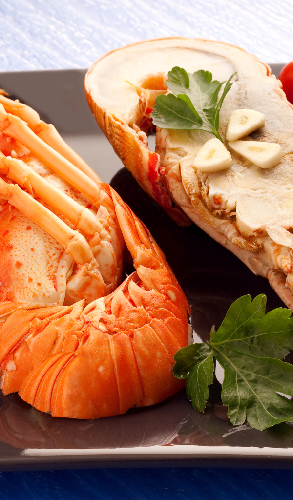 Аппетитный вареный омар на тарелке с помидорами 