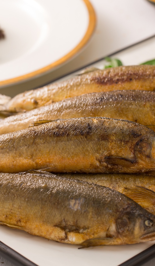 Аппетитная жареная рыба на тарелке