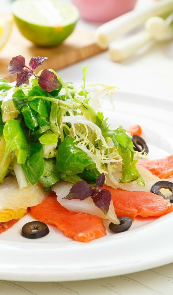 Аппетитный салат с морепродуктами на белой тарелке 