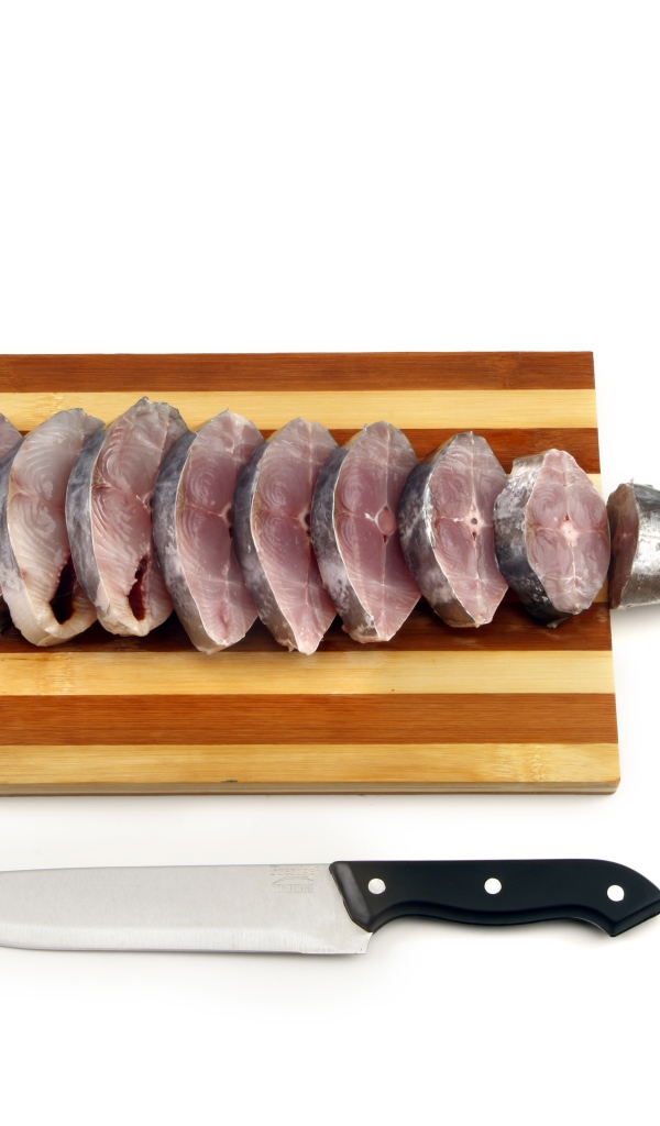 Свежая рыба кусочками на деревянной доске с ножом 