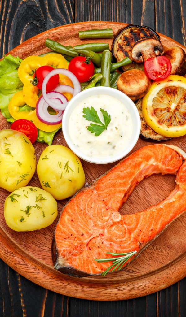 Жареный кусок рыбы с овощами и соусом