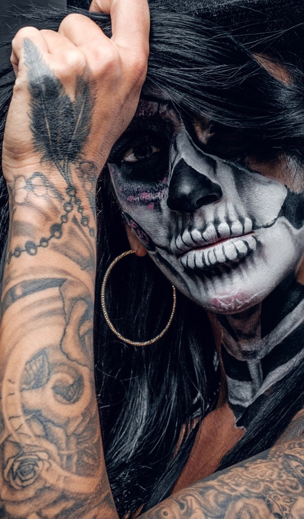 Брюнетка с татуировками и мейкапом на лице 