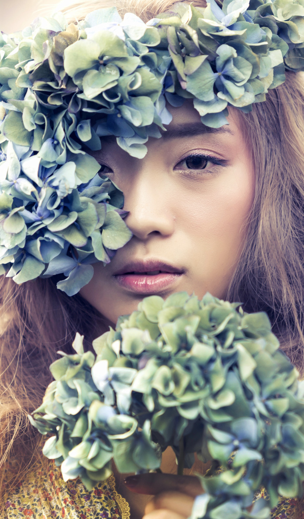 Молодая девушка азиатка с венком из цветов на голове