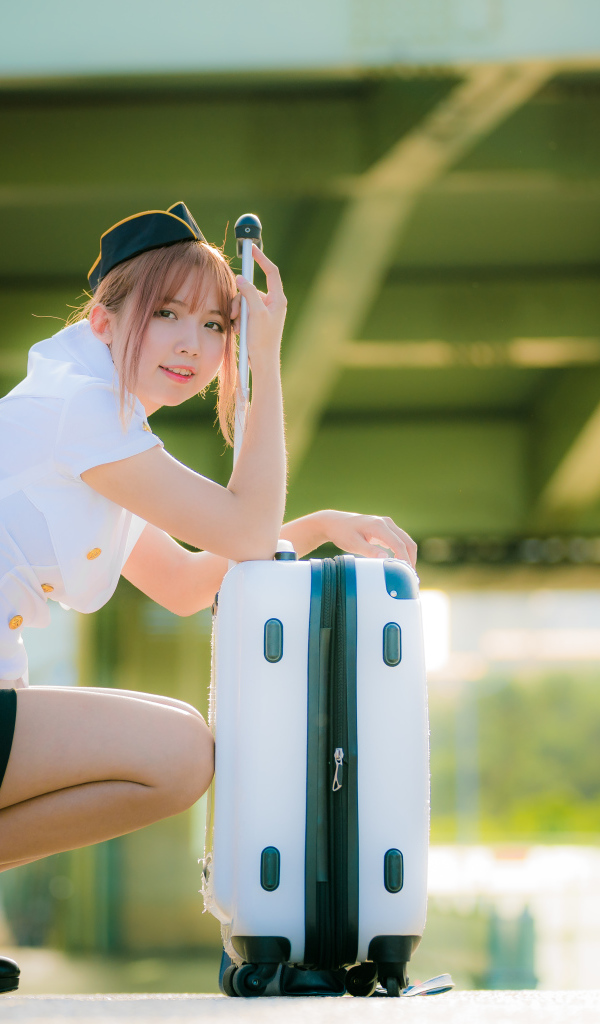 Девушка азиатка стюардесса с чемоданом