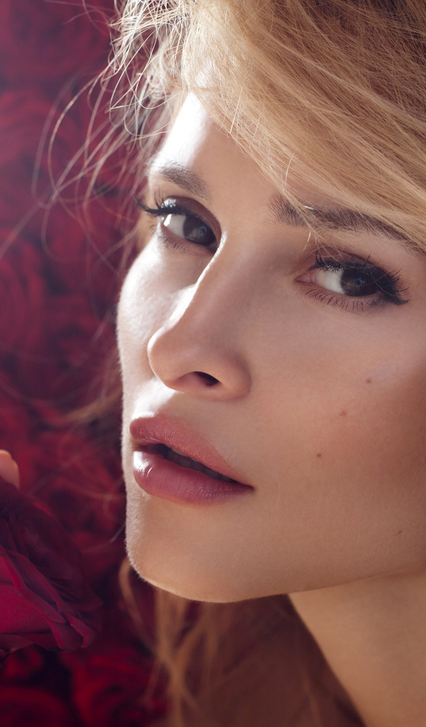 Красивая девушка блондинка с красной розой в руке