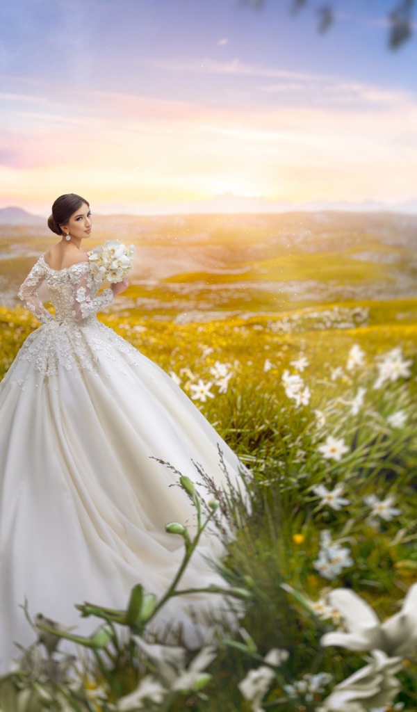 Красивая девушка невеста в белом платье в поле с белыми цветами 