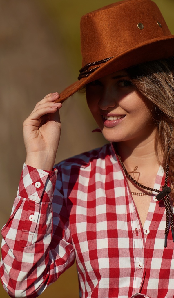 Красивая девушка брюнетка в ковбойской шляпе 