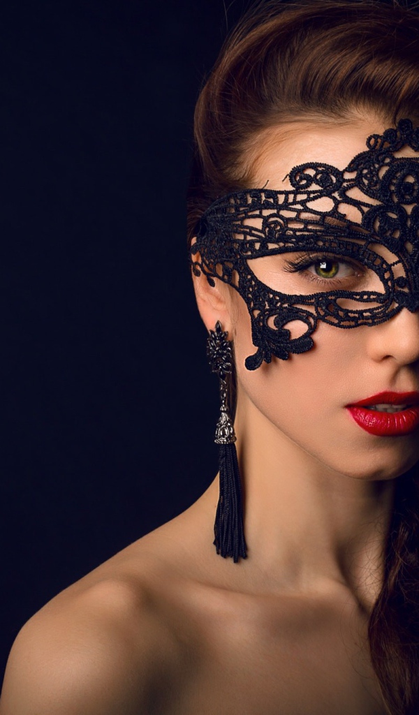 Красивая брюнетка с черной маской на лице 
