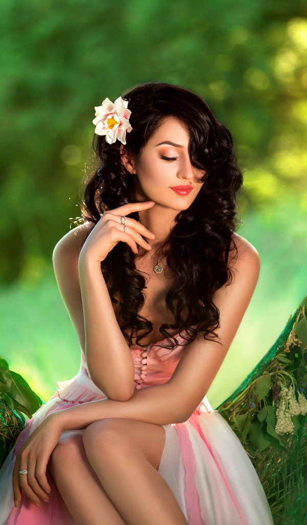 Красивая брюнетка с розовым цветком в волосах