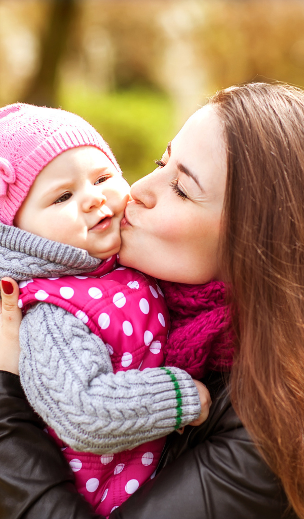 Красивая девушка держит в руках маленького ребенка