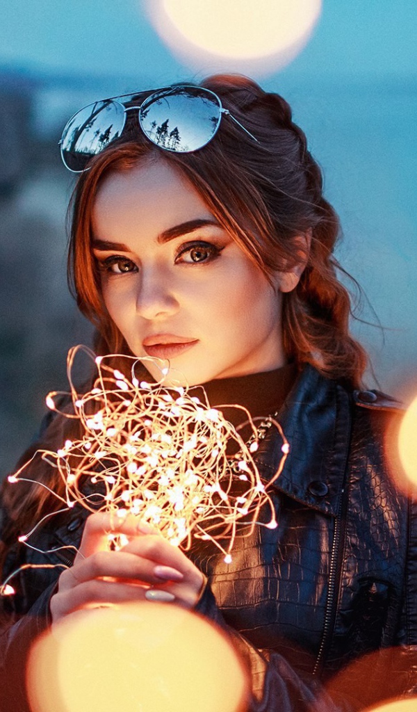 Красивая девушка с включенной гирляндой 