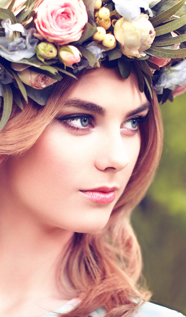 Красивая девушка с венком из цветов на голове 