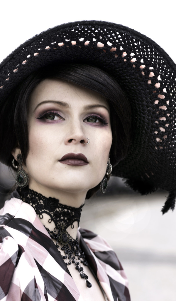 Красивая зеленоглазая девушка в большой черной шляпе