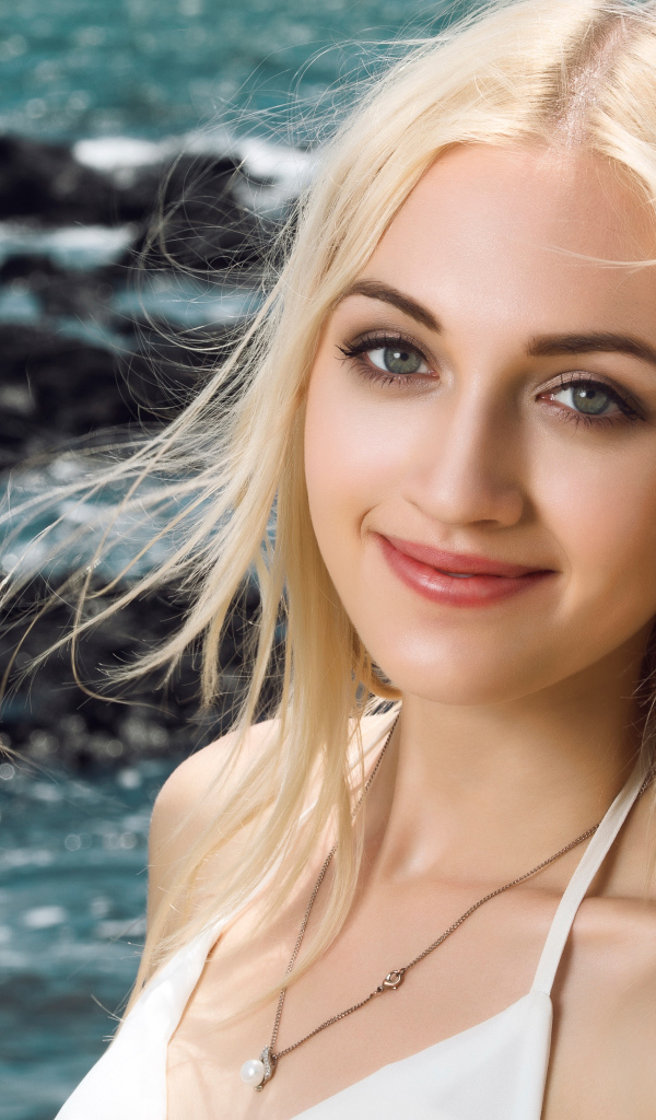 Красивая длинноволосая девушка блондинка на фоне океана 