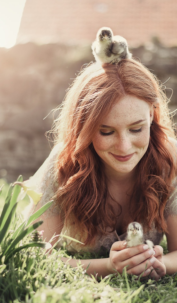 Красивая рыжеволосая девушка с маленькими цыплятами  