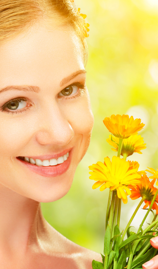 Красивая улыбающаяся девушка с цветами календулы в волосах