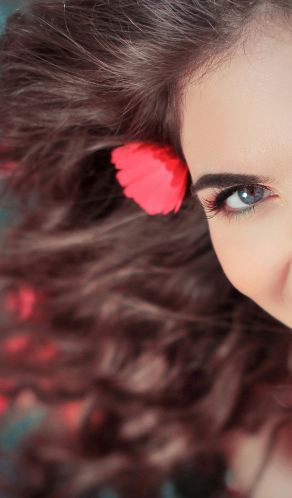 Красивая улыбающаяся девушка с розовыми цветами в волосах 