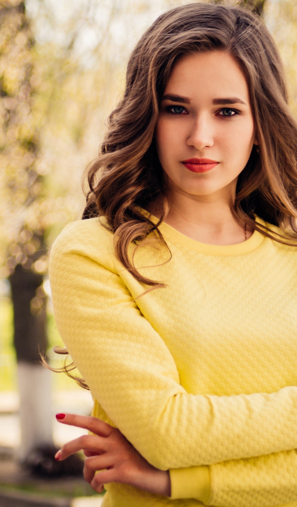 Красивая молодая голубоглазая девушка в желтом свитере