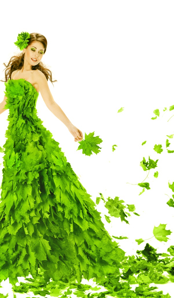 Красивая молодая девушка в платье из зеленых листьев на белом фоне